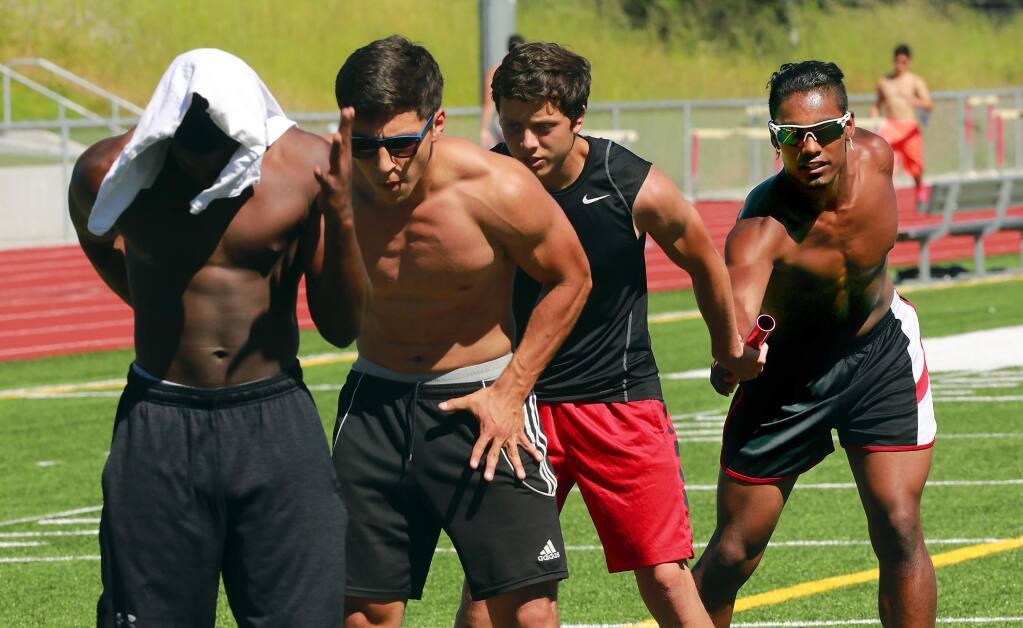 El Molino track team standout Sire Clark, far right, practices passing the baton for the 4x100-meter relay during practice on Tuesday afternoon. (John Burgess/The Press Democrat)
