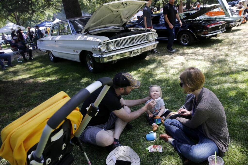 Chris Thompson wipes the mouth of his 14-month-old daughter Wendy and is joined by his wife Jen during the Father's Day Show and Shine Car Show at Juilliard Park on Sunday, June 17, 2018 in Santa Rosa, California . (BETH SCHLANKER/The Press Democrat)