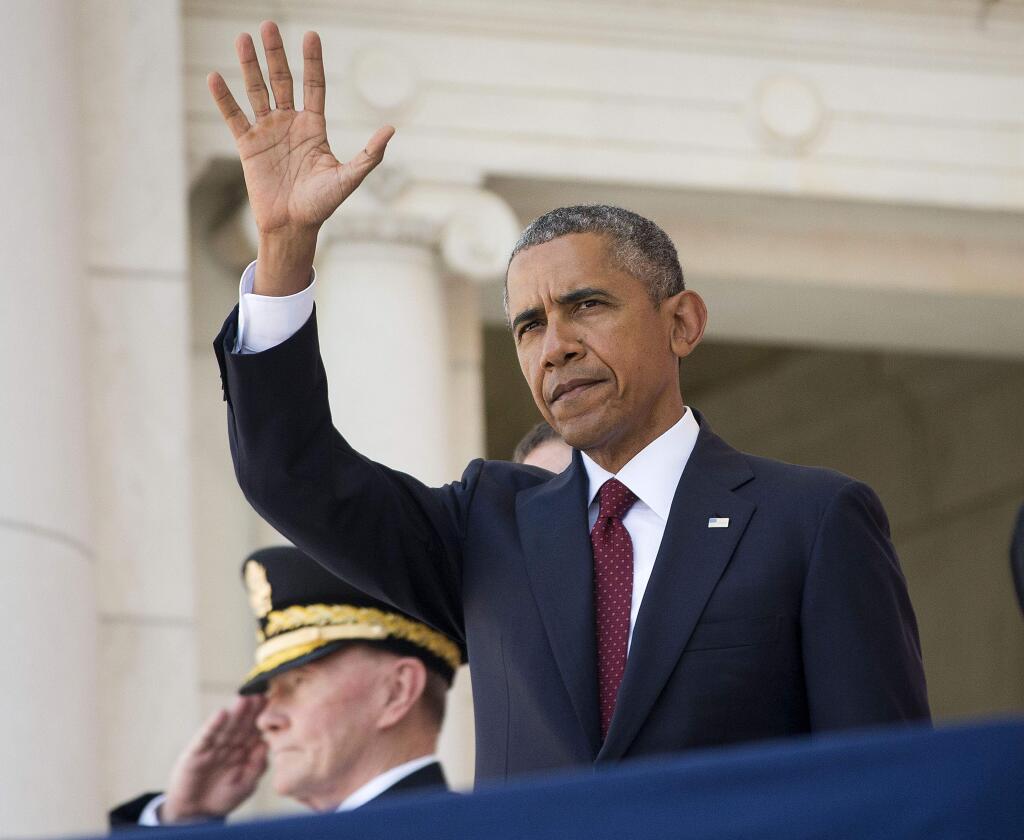 President Barack Obama, accompanied by Joint Chiefs Chairman Gen. Martin Dempsey, waves as he introduced before speaking in the Memorial Amphitheater at Arlington National Cemetery in Arlington, Va., Monday, May 25, 2015, during a Memorial Day ceremony. (AP Photo/Pablo Martinez Monsivais)