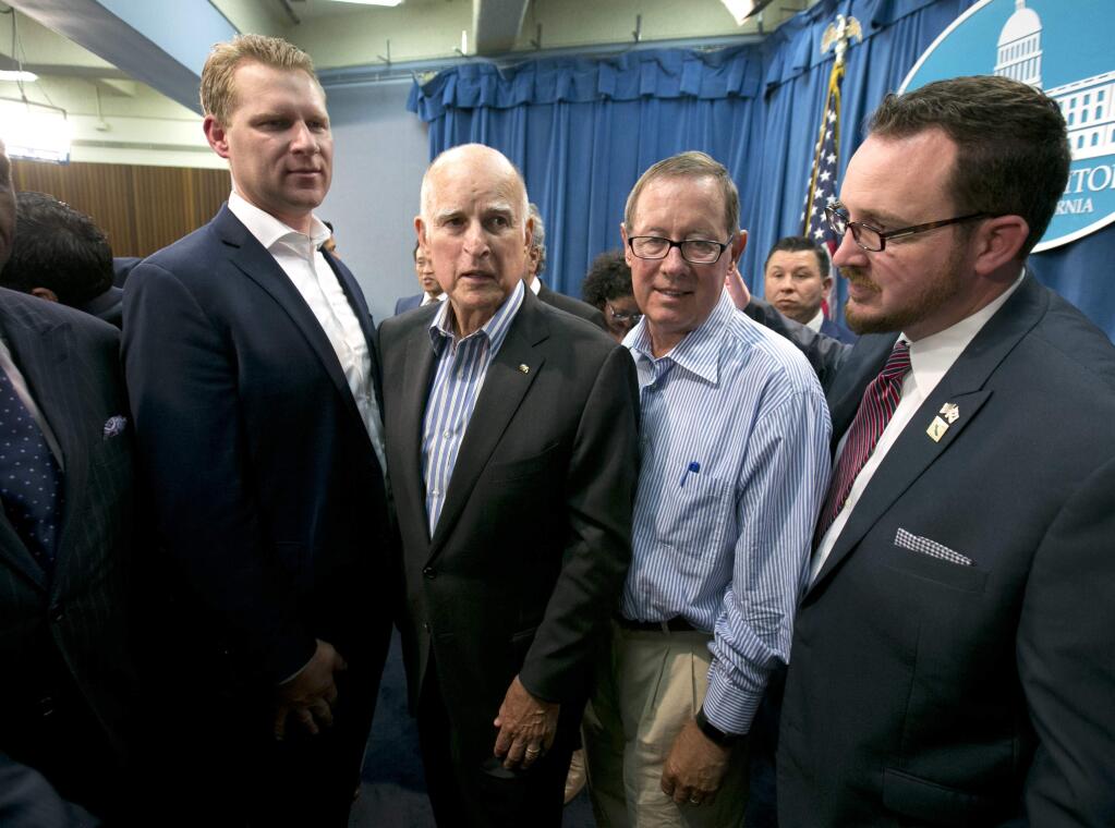 FILE - In this Monday, July 17, 2017 file photo Gov. Jerry Brown, second from left, flanked by Republicans, Assembly Leader Chad Mayes, of Yucca Valley, left, Tom Berryhill, of Twain Harte, and Devon Mathis, of Visalia, right, leaves a news conference held after the Legislature approved a a pair of climate change bills, in Sacramento, Calif. Mayes, Berryhill and Mathis voted with the Democratic majority to extend California's cap-and-trade program despite opposition from much of the GOP base. (AP Photo/Rich Pedroncelli,file )