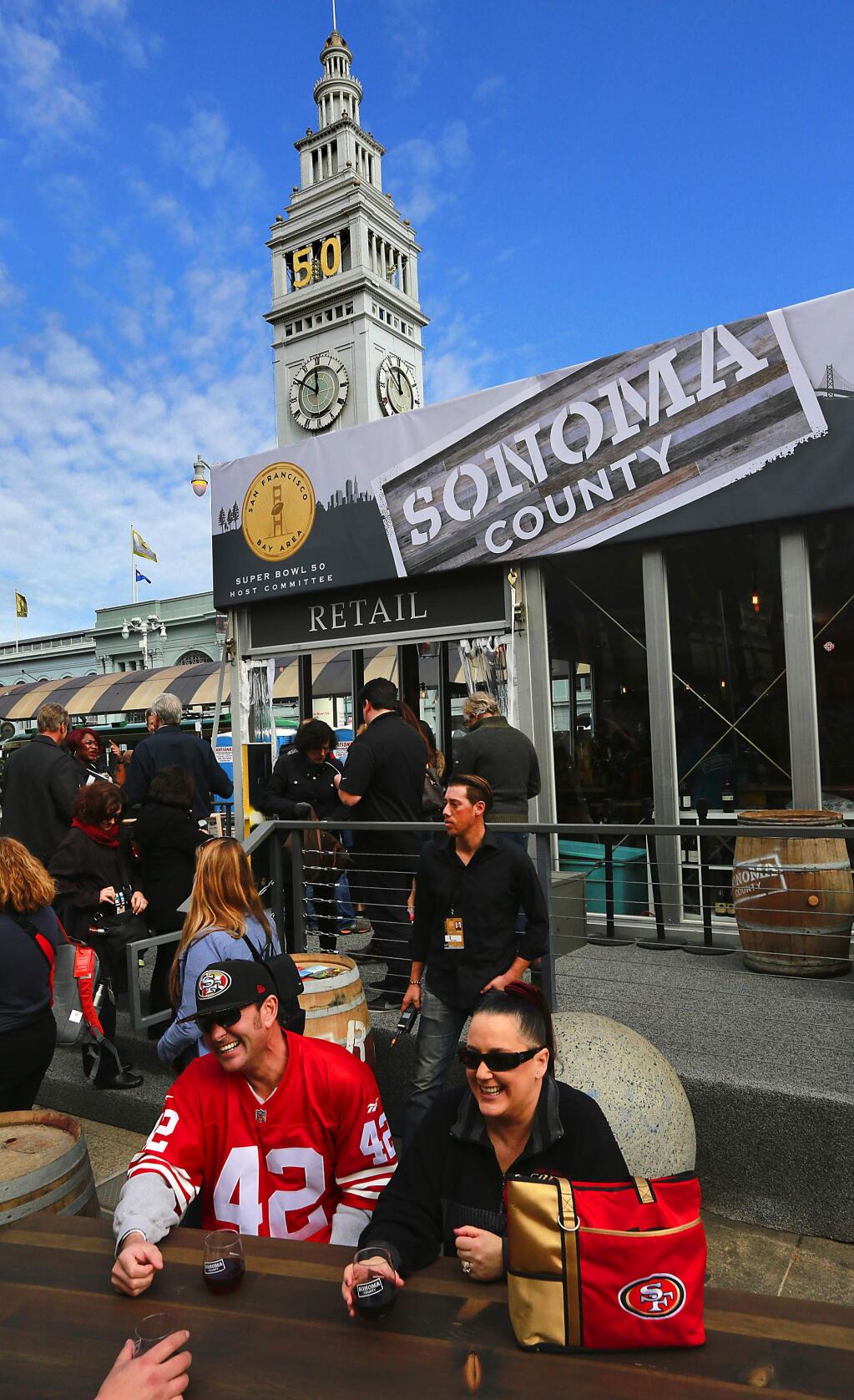 Paul, left, and Cheryl Pollino of Concord taste Sonoma County wines in the outside seating area at the Sonoma County wine and tourism tent in San Francisco's Super Bowl City. (JOHN BURGESS / The Press Democrat)