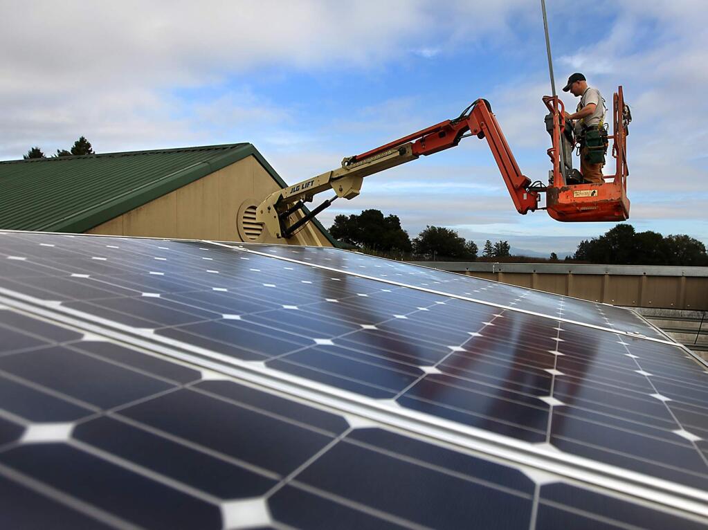 (File photo) West Coast Solar Energy worker Sam Epperson finishes his day after he and coworkers install a solar array on the roof of Merry Edward Winery in Sebastopol. (Kent Porter / Press Democrat) 2012
