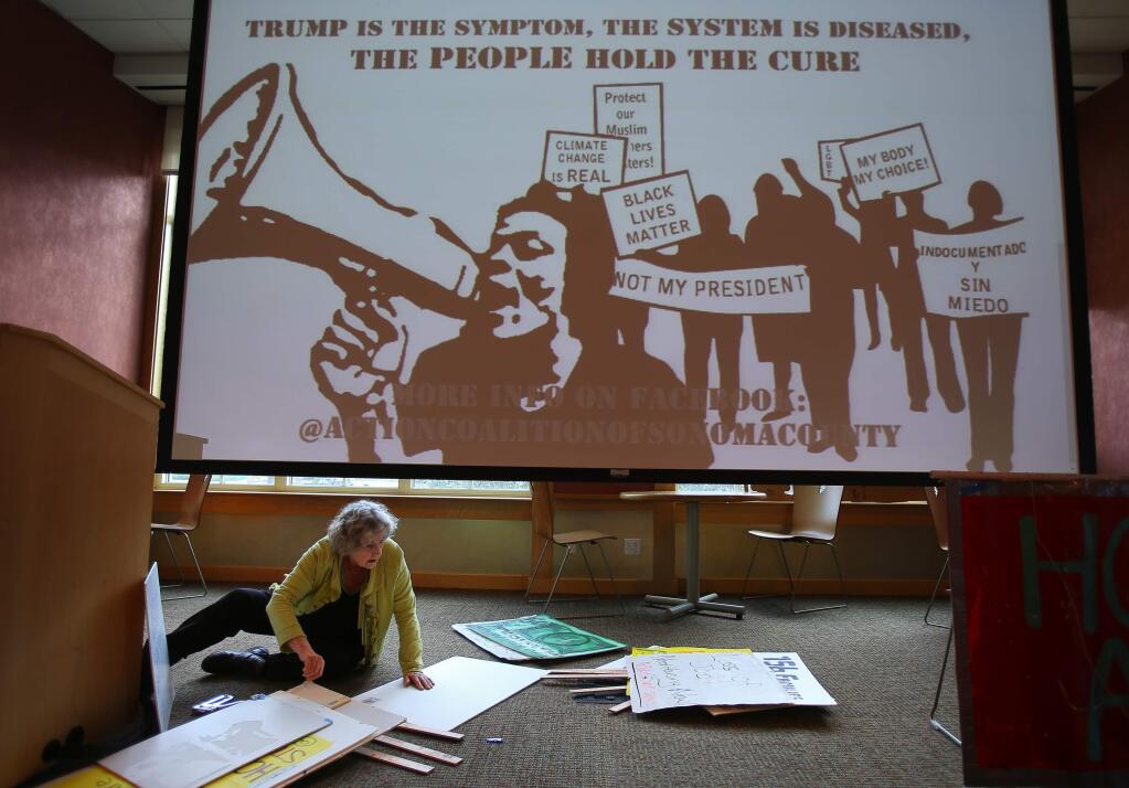 Anita Lafollette, with Homeless Action, makes signs prior to a march protesting President Donald Trump, at Santa Rosa Junior College, on Friday, January 20, 2017. (Christopher Chung/ The Press Democrat)