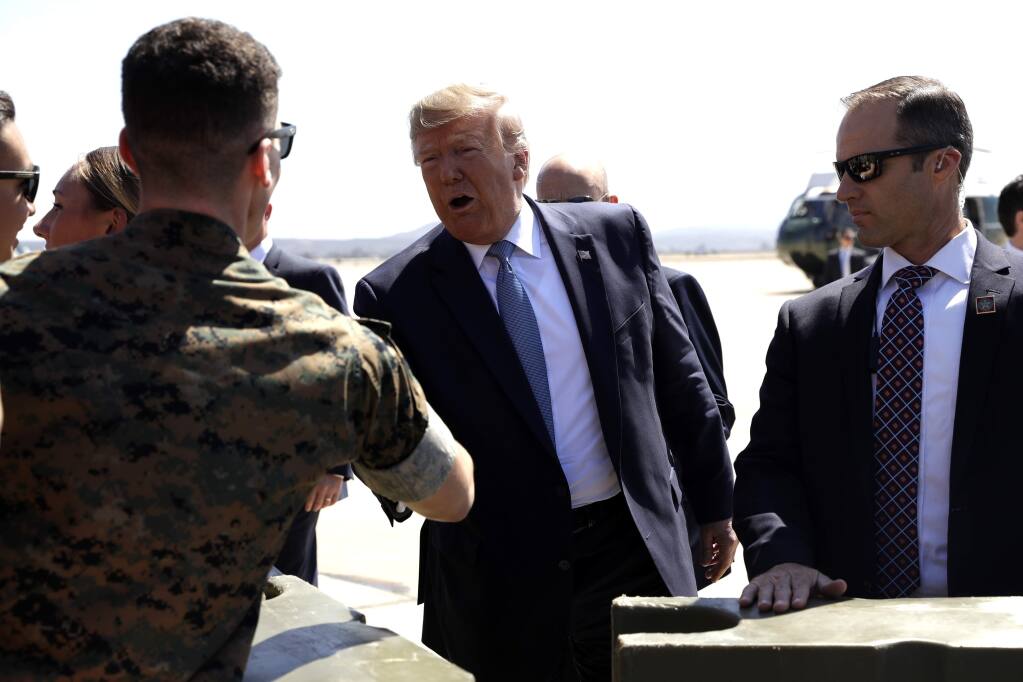 President Donald Trump greets supporters as he arrives at Marine Corps Air Station Miramar to attend a fundraiser and visit a section of the border wall, Wednesday, Sept. 18, 2019, in San Diego. (AP Photo/Evan Vucci)