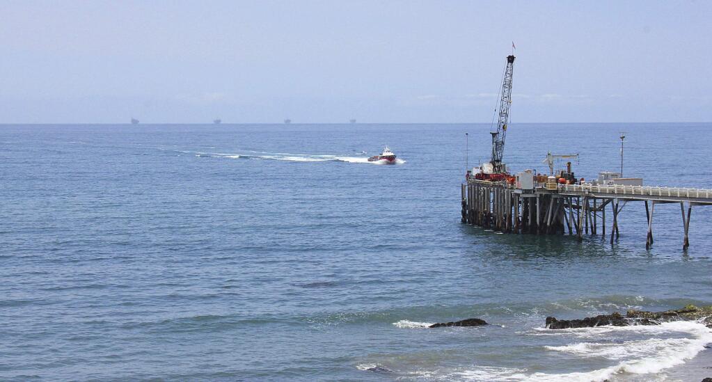 FILE- This May 16, 2015, file photo shows oil drillings offshore of a service pier in the Santa Barbara Channel off the coast of Southern California near Carpinteria. Opposition to the Trump administration's plan to expand offshore drilling mounted Wednesday, Jan. 10, 2018. The plan could open up federal waters off the California coast for the first time in more than three decades. The Channel is one of those areas that could open up. (AP Photo/John Antczak, File)