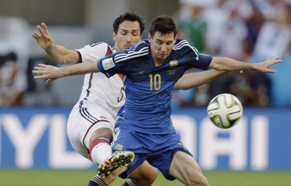 Argentina's Lionel Messi is challenged by Germany's Mats Hummels during the World Cup final soccer match between Germany and Argentina at the Maracana Stadium in Rio de Janeiro, Brazil, Sunday, July 13, 2014. (AP Photo/Victor R. Caivano)