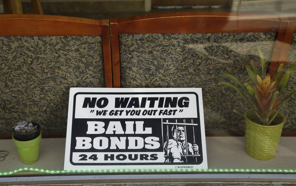 A sign is seen in the window of a bail bonds office across from the Hall of Justice in San Francisco. (ERIC RISBERG / Associated Press)