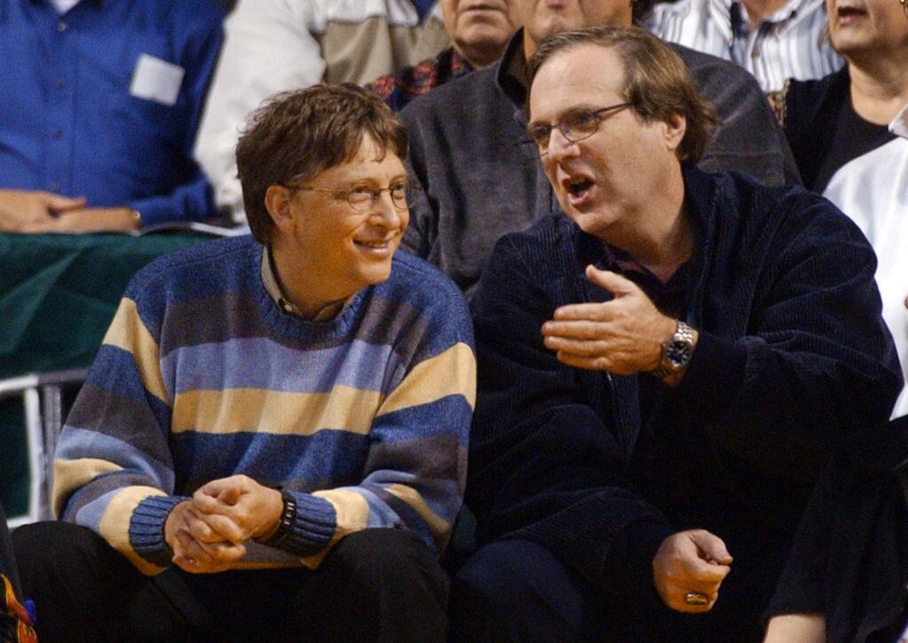FILE - In this March 11, 2003 file photo, Microsoft Chairman Bill Gates, left, chats with Portland Trail Blazers owner and former business partner Paul Allen during a game between the Trail Blazers and Seattle SuperSonics in Seattle. Allen, billionaire owner of the Trail Blazers and the Seattle Seahawks and Microsoft co-founder, died Monday, Oct. 15, 2018 at age 65. Earlier this month Allen said the cancer he was treated for in 2009, non-Hodgkin's lymphoma, had returned. (AP Photo/Elaine Thompson, File)