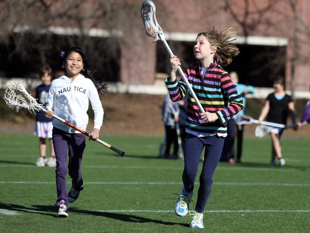 Emma Simon, 10, right, and Cindy Vargas, 11, try playing lacrosse during the 16th Annual Girls Sports Expo in Santa Rosa in 2013. (CHRISTOPHER CHUNG/ PD FILE)