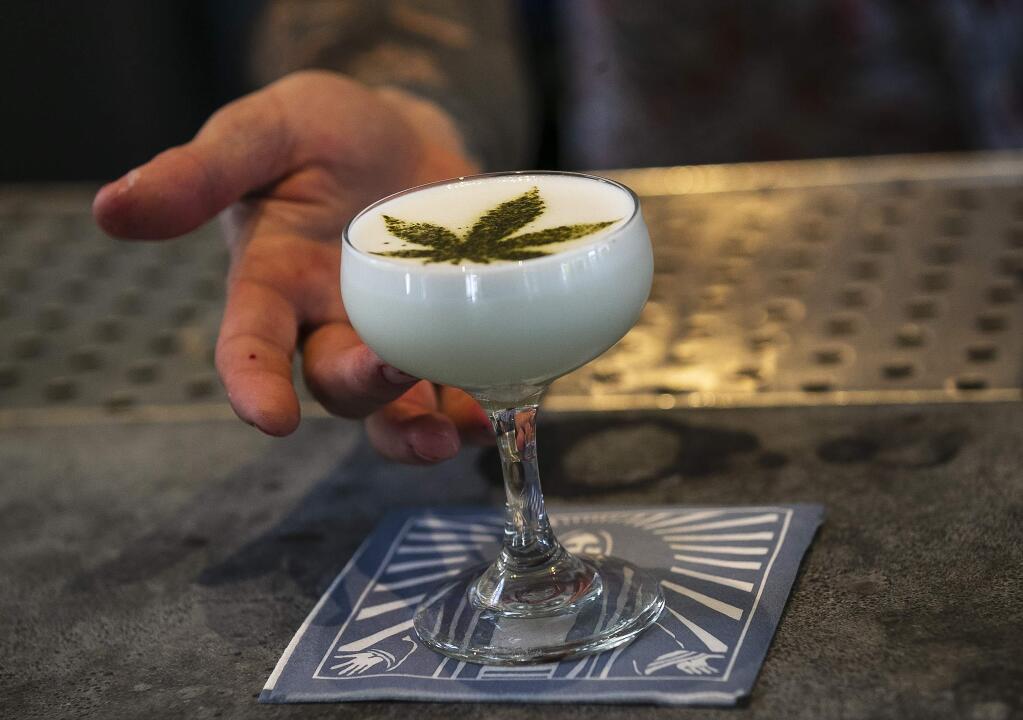 In this April 19, 2018, photo Maxwell Reis, beverage director serves a drink containing Cannabidol CBD extract with a marijuana leaf motif at the Gracias Madre restaurant in West Hollywood, Calif. The hemp-derived CBD extract is popping up in everything, from cosmetics to chocolate bars to bottled water to bath bombs to pet treats. (AP Photo/Damian Dovarganes)