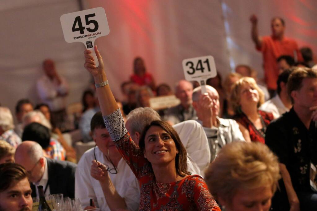 Alvin Jornada / The Press DemocratEva Bertran of Gloria Ferrer holds her bidding paddle high for the Fund-a-Future segment of the Sonoma Harvest Wine Auction to support children in the local community, at Chateau St. Jean in Kenwood, Sunday.