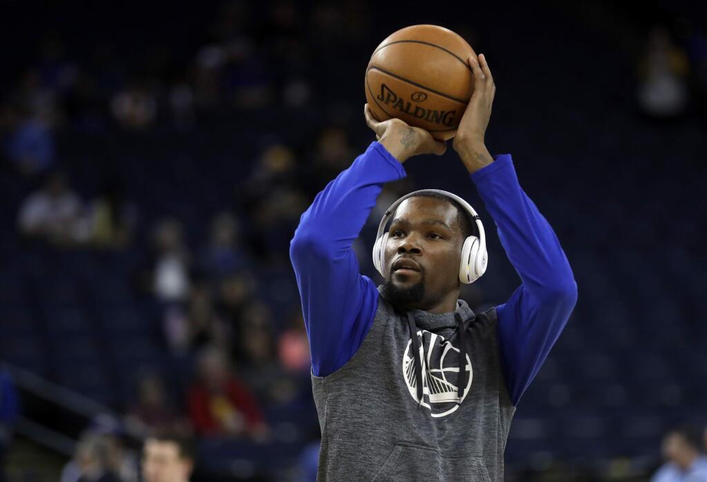 The Golden State Warriors' Kevin Durant warms up before the team's game against the New Orleans Pelicans on Saturday, April 8, 2017, in Oakland. (AP Photo/Marcio Jose Sanchez)