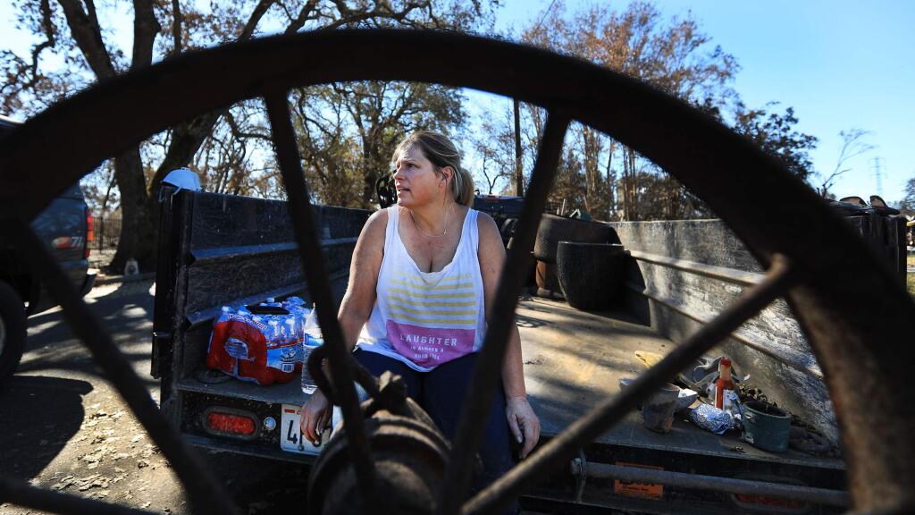 Kris Rietman rests after she and her husband Willie remove burned belongings of their home on Ursuline Road in the Larkfield area, Monday Oct. 23, 2017 as the begin the task of clean up an debris removal. (Kent Porter / Press Democrat) 2017