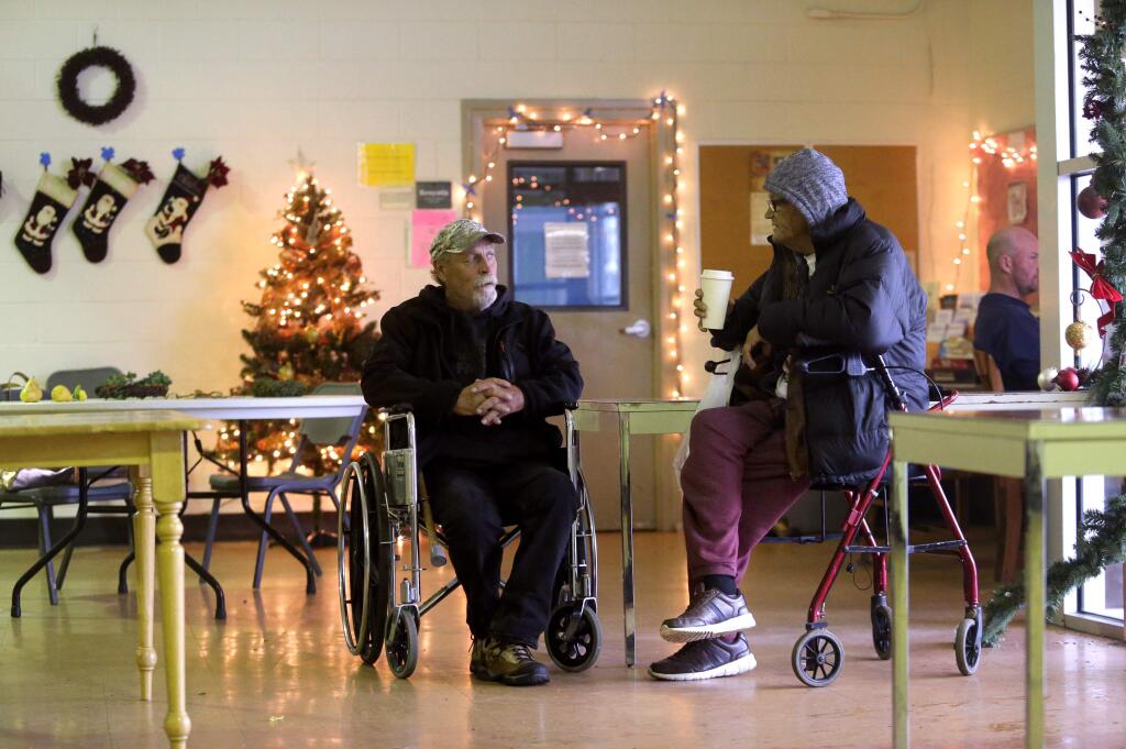 Brian Graham, left, and Jerry Osterberg, talk with each other in the dining area of the Samuel L. Jones Hall, a homeless shelter, in Santa Rosa on Sunday, December 16, 2018. Graham, who is preparing for knee surgery and is staying Nightingale area of the shelter, complains of substandard conditions including rainwater leaking onto the beds, lack of heat, and no windows. (BETH SCHLANKER/ The Press Democrat)