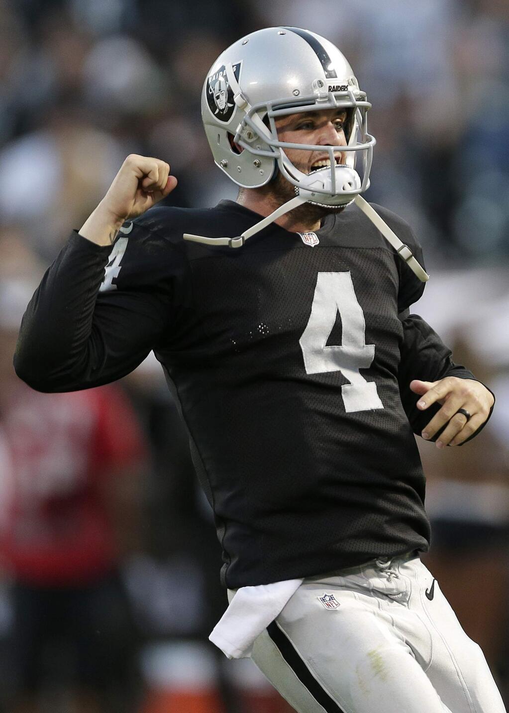 Oakland Raiders quarterback Derek Carr (4) celebrates after throwing a 36-yard touchdown pass to wide receiver Denarius Moore during the first quarter of an NFL preseason football game against the Seattle Seahawks in Oakland, Calif., Thursday, Aug. 28, 2014. (AP Photo/Marcio Jose Sanchez)
