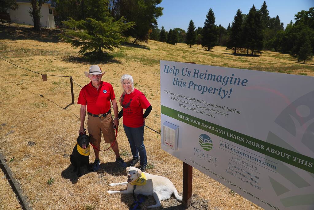 Craig and Sandy Steele, with their dogs Pixar and Tamika, would like to see Wikiup Commons include a community center and dog park, and not high density housing. Wikiup Commons is located on the site of the former Wikiup public golf course.(Christopher Chung/ The Press Democrat)