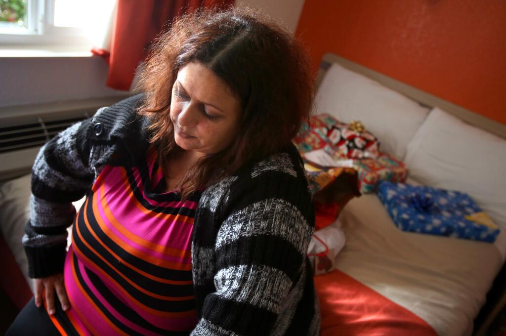 Wendy Laupoa and her family are being put up in the Motel 6 after their apartment was damaged in a fire, in Rohnert Park on Wednesday, December 24, 2014. Laupoa, her two children, and boyfriend escaped the blaze, and firefighters brought over some Christmas presents that were not lost in the fire.(Christopher Chung/ The Press Democrat)