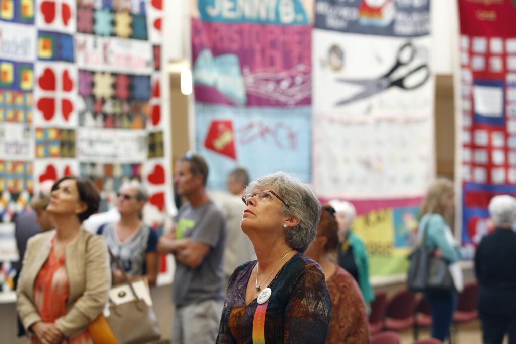 Judy Farrell views panels of the AIDS Memorial Quilt at Congregation Shomrei Torah on Sunday, June 14, 2015 in Santa Rosa. (BETH SCHLANKER / The Press Democrat)
