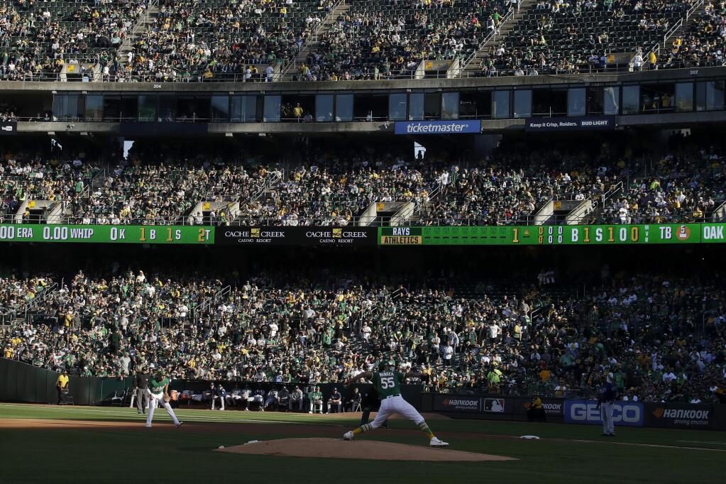 Fans at RingCentral Coliseum watch as Oakland Athletics pitcher Sean Manaea (55) throws to a Tampa Bay Rays batter during the first inning of an American League wild-card baseball game in Oakland, Calif., Wednesday, Oct. 2, 2019. (AP Photo/Jeff Chiu)