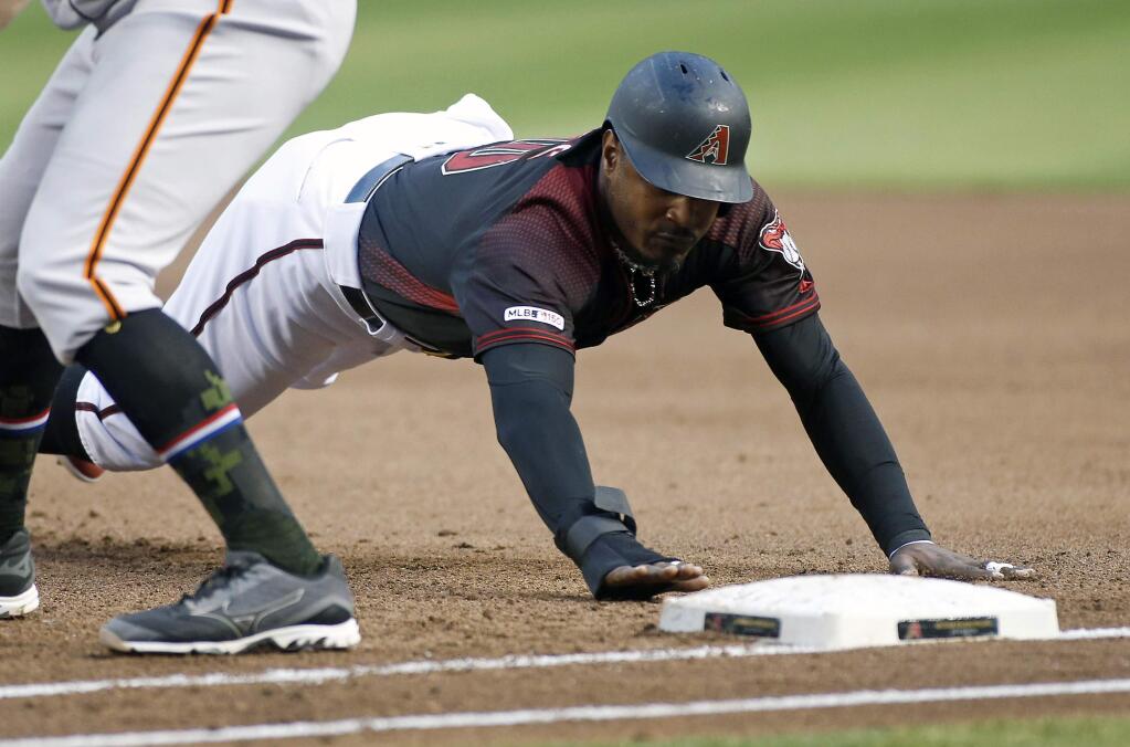 Arizona Diamondbacks' Adam Jones dives back to first base on a pickoff-attempt by the San Francisco Giants during the second inning of a baseball game, Friday, May 17, 2019, in Phoenix. (AP Photo/Ralph Freso)