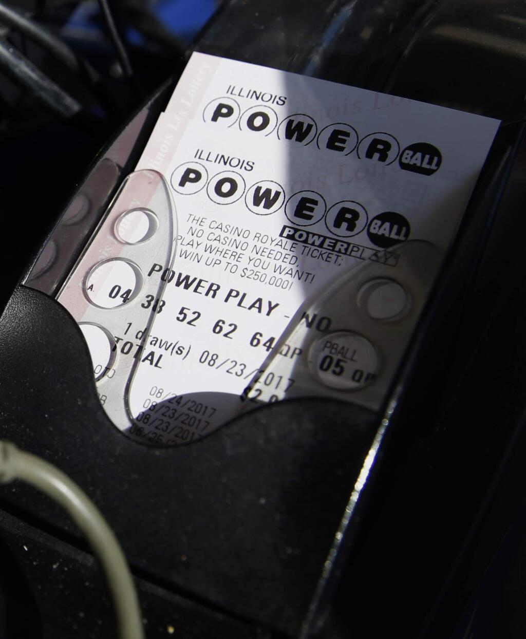 A Powerball lottery ticket is printed out of a lottery machine at a convenience store Wednesday, Aug. 23, 2017, in Northbrook, Ill. Lottery officials said the grand prize for Wednesday night's drawing has reached $700 million. The second -largest on record for any U.S. lottery game. (AP Photo/Nam Y. Huh)