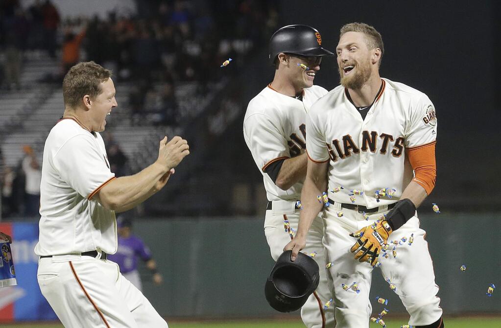 The San Francisco Giants' Hunter Pence, right, celebrates with teammates after hitting a sacrifice fly to score Orlando Calixte for the winning run during the ninth inning against the Colorado Rockies in San Francisco, Tuesday, Sept. 19, 2017. The Giants won 4-3. (AP Photo/Jeff Chiu)