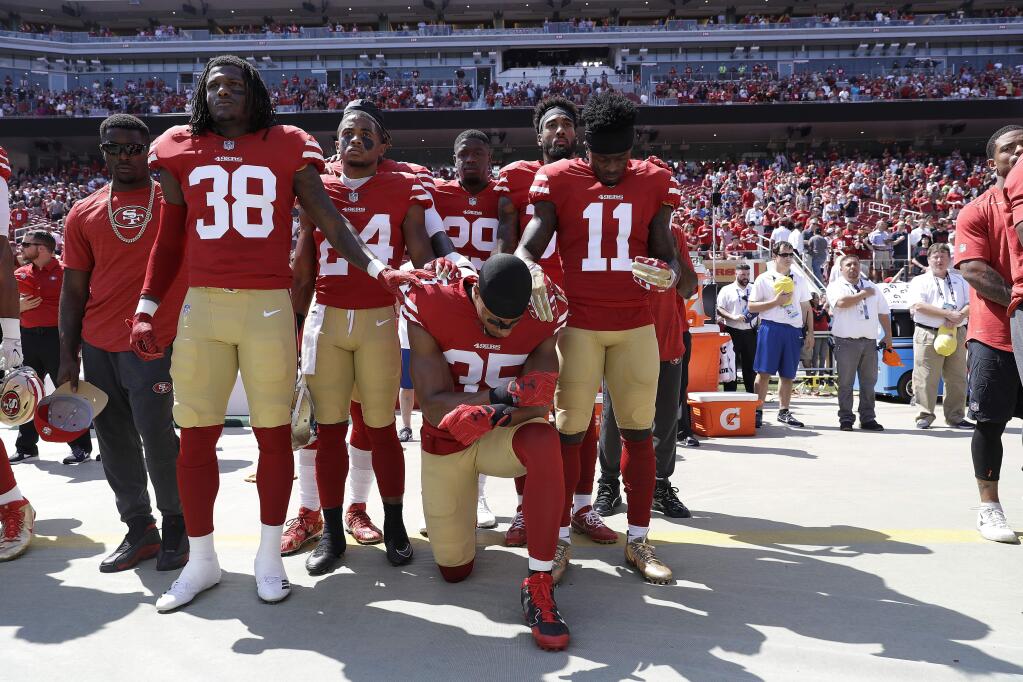 San Francisco 49ers safety Eric Reid kneels during the national anthem in front of teammates before a game between the 49ers and the Carolina Panthers in Santa Clara, Sunday, Sept. 10, 2017. (AP Photo/Marcio Jose Sanchez)