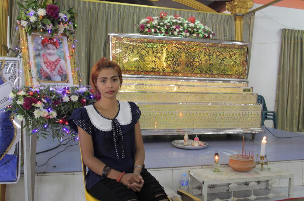 Chiranut Trairat, mother of an 11-month-old baby girl, sits in front of her daughter's coffin at Si Sunthon temple in Phuket, Thailand, Wednesday, April 26, 2017. Her husband upset with her hanged their daughter on Facebook Live and then killed himself, police said. (AP Photo)