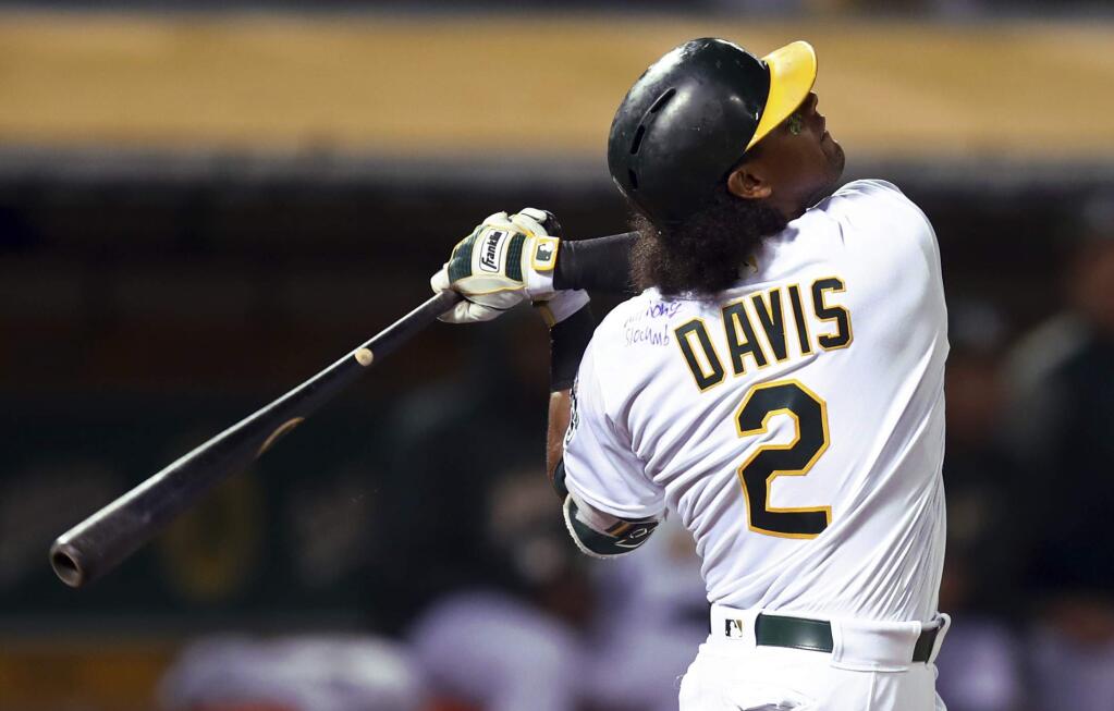 Oakland Athletics' Khris Davis swings on a pitch from Texas Rangers' Bartolo Colon in the fifth inning of a baseball game, Monday, Aug. 20, 2018, in Oakland, Calif. Davis' jersey is signed by Anthony Slocumb, a child from the Make A Wish Foundation, seen on Davis' left shoulder. Davis hit his 37th home run of the season wearing the signed jersey. (AP Photo/Ben Margot)
