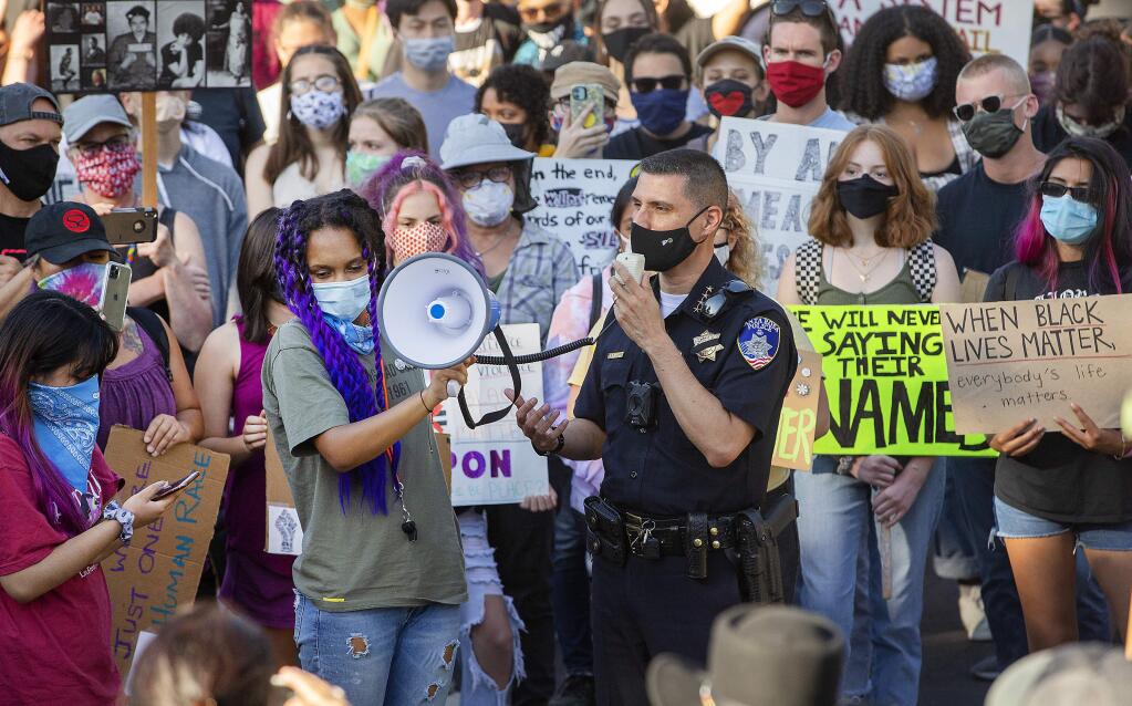 Youth rally organizer Joy Ayodele, 18, holds a megaphone so Santa Rosa police chief Ray Navarro could answer questions posed by protesters in the parking lot of city hall on Monday. (photo by John Burgess/The Press Democrat).