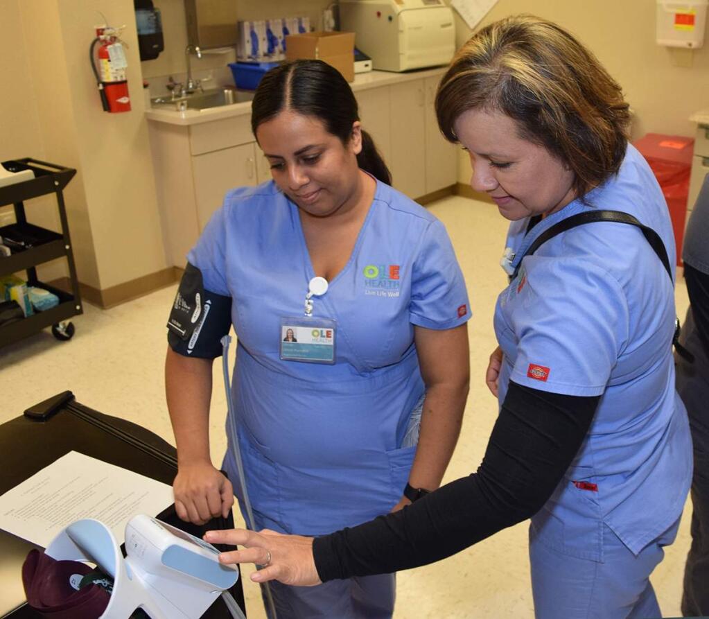 Olinda Plancarte, R.N., and Claudia Provedor, R.N., handle a blood-pressure machine at OLE Health's new location in east Fairfield on Nov. 2, 2018. (COURTESY OF OLE HEALTH)