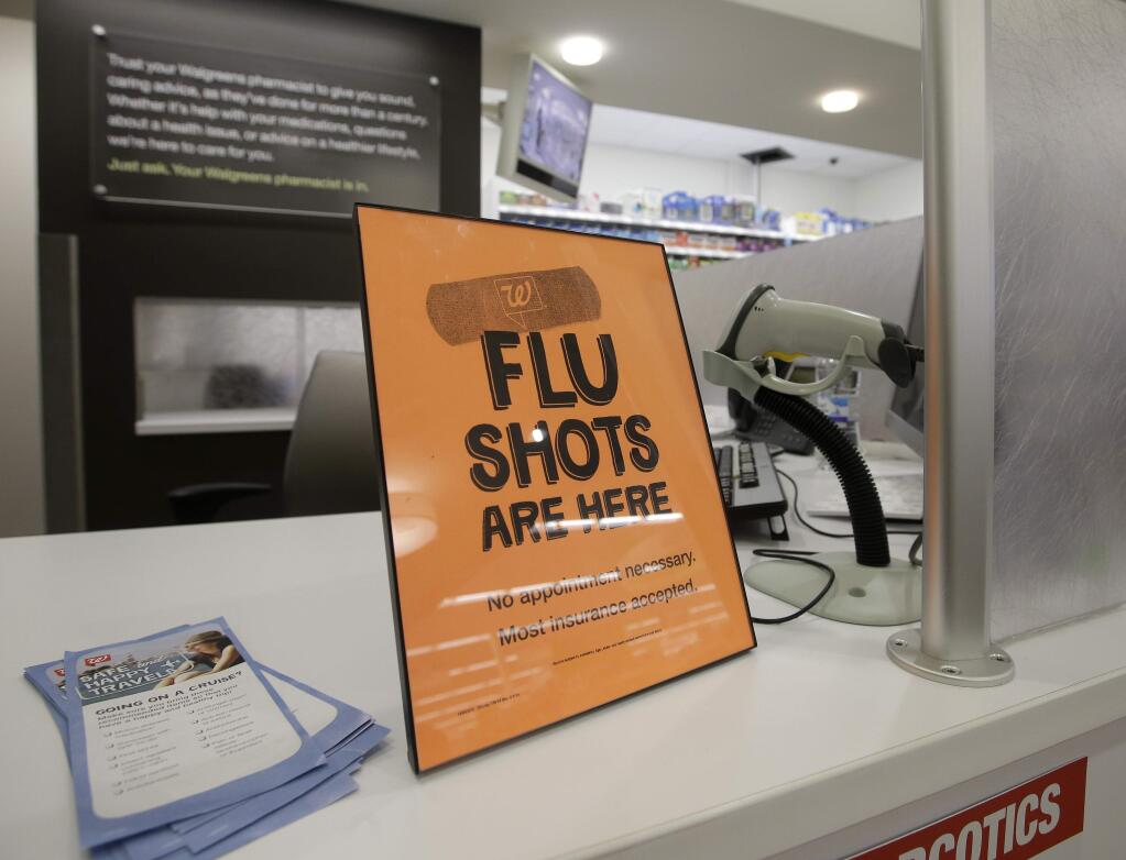 FILE - In this Sept. 16, 2014 file photo, a sign lets customers know they can get a flu shot in a Walgreen store in Indianapolis. The flu vaccine may not be very effective this winter, according to U.S. health officials who worry this may lead to more serious illnesses and deaths. The Centers for Disease Control and Prevention issued an advisory to doctors about the situation Wednesday, Dec. 3, 2014. (AP Photo/Darron Cummings, File)