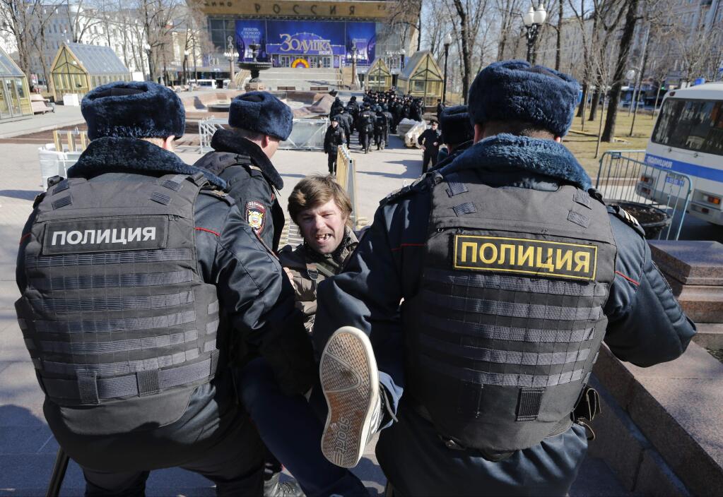 Police detain a protester in downtown Moscow on Sunday. Russia's leading opposition figure, Alexei Navalny and his supporters aim to hold anti-corruption demonstrations throughout Russia, but authorities are denying permission and police have warned they won't be responsible for 'negative consequences' of unsanctioned gatherings. (ALEXANDER ZEMLIANICHENKO / Associated Press)