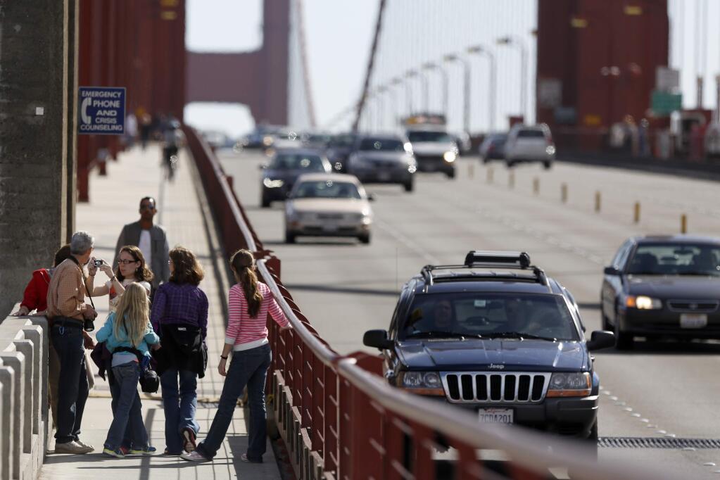 Tourists take photos as they walk across the Golden Gate Bridge on Monday, Oct. 27, 2014. (BETH SCHLANKER/ PD)