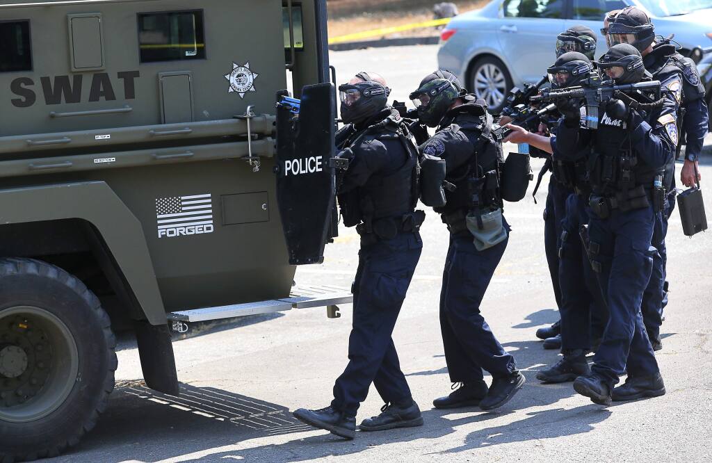 Members of the Santa Rosa Police Department SWAT team prepare to enter a building during a training simulation in Santa Rosa on Thursday, Aug. 10, 2017. (Christopher Chung / The Press Democrat)