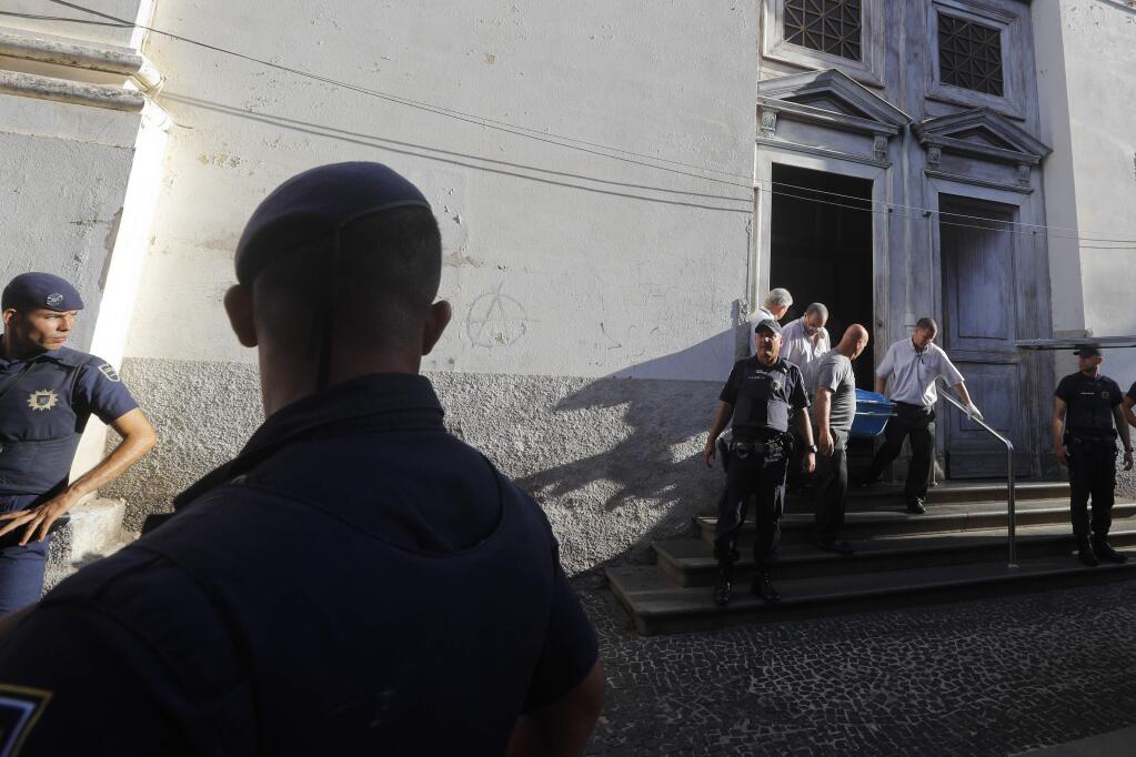 Police remove the body of a shooting victim from the Metropolitan Cathedral in Campinas, Brazil, Tuesday, Dec. 11, 2018. A man opened fire in the cathedral after Mass on Tuesday, killing four and leaving four others injured before taking a bullet in the ribs in a firefight with police and then shooting himself in the head, according to authorities. (AP Photo/Victor R. Caivano)