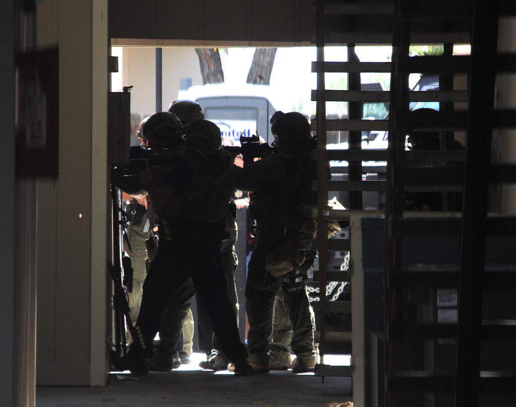 Sparks and Reno police officers work during a raid at Courtside Garden Apartments in Sparks, Nev. on Tuesday, Sept. 22, 2015. Two people were found dead after a standoff at the apartment near Sparks High School that police believe was connected to an early morning homicide at a home in northwest Reno. (Jason Bean/The Gazette-Journal via AP)