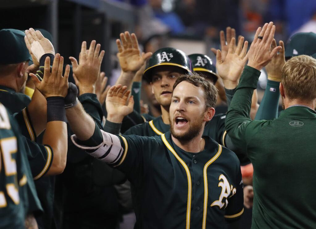 The Oakland Athletics' Jed Lowrie celebrates hitting a grand slam against the Detroit Tigers in the eighth inning Tuesday, Sept. 19, 2017. (AP Photo/Paul Sancya)