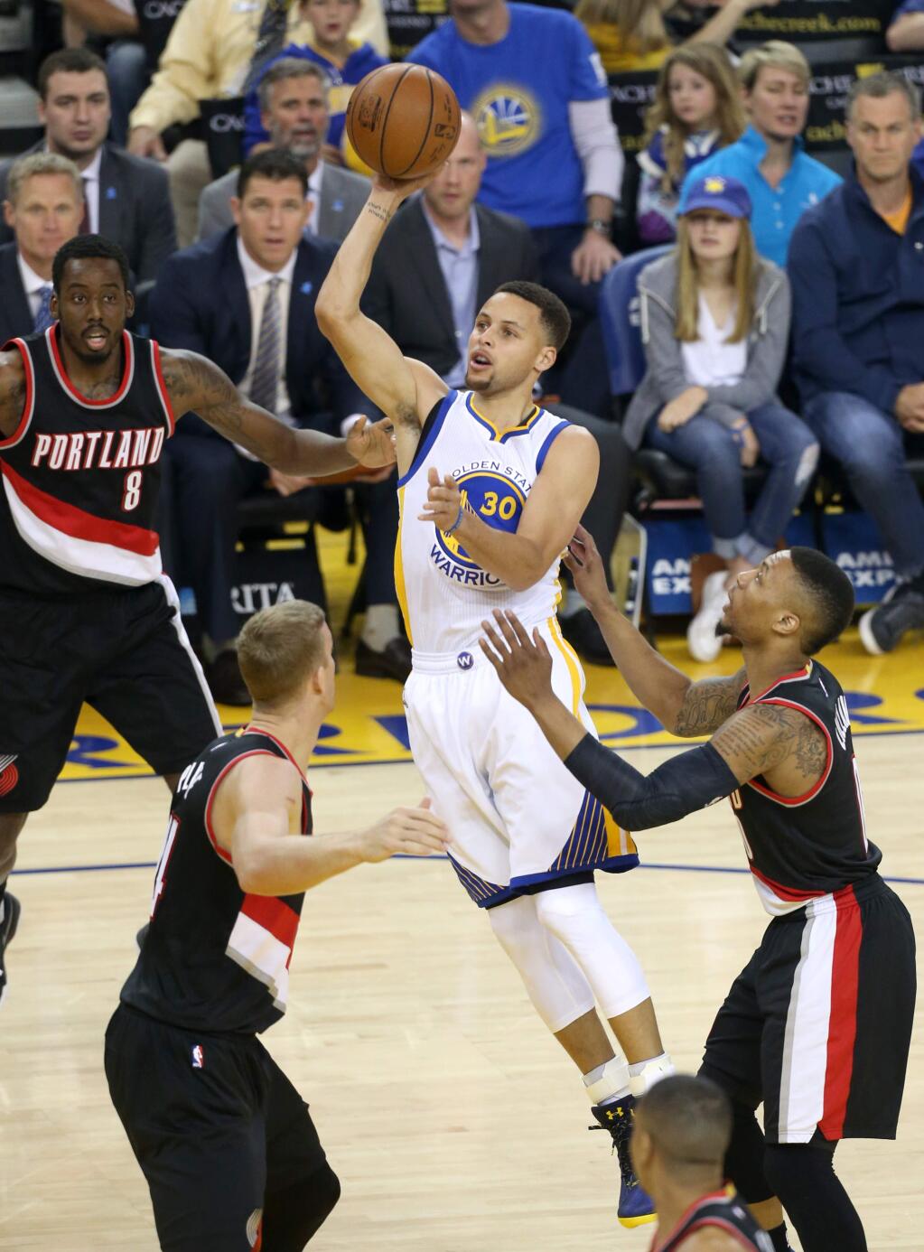 Golden State Warriors guard Stephen Curry floats a shot over the Portland Trailblazers defense during their game in Oakland on Sunday, April 3, 2016. (Christopher Chung/ The Press Democrat)