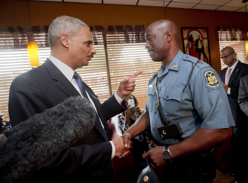 Attorney General Eric Holder talks with Capt. Ron Johnson of the Missouri State Highway Patrol at Drake's Place Restaurant, Wednesday, Aug. 20, 2014 in Florrissant, Mo. (AP Photo/Pablo Martinez Monsivais, Pool)