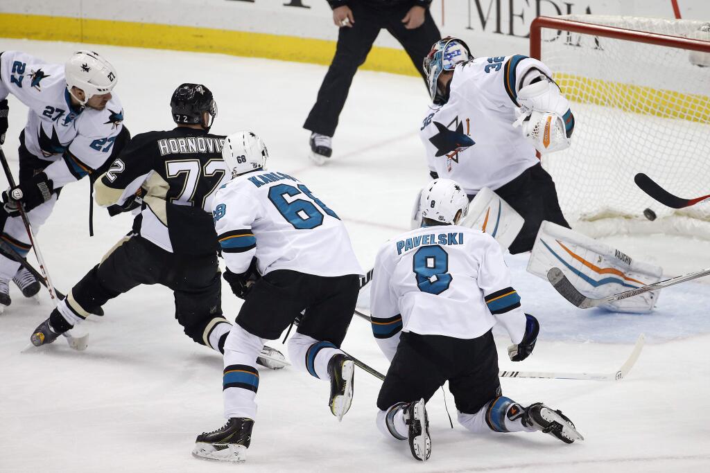 Pittsburgh Penguins' Patric Hornqvist (72) puts the puck behind San Jose Sharks goalie Alex Stalock (32) for a goal in the first period of a game against the San Jose Sharks in Pittsburgh Sunday, March 29, 2015. (AP Photo/Gene J. Puskar)