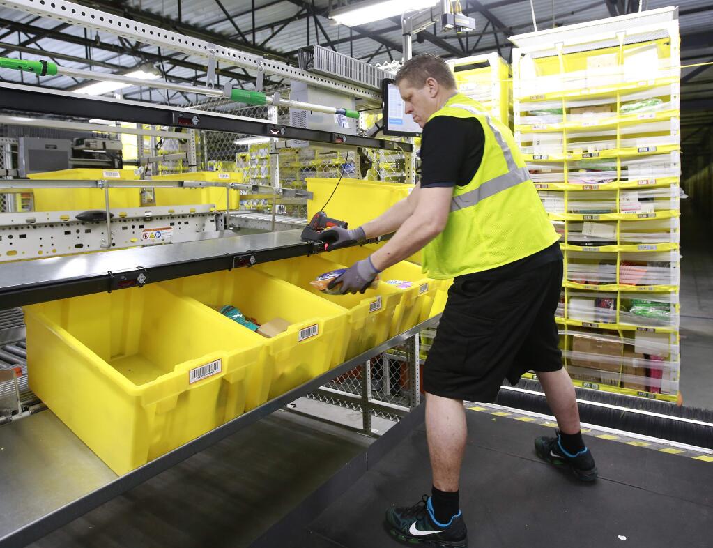Merchandise is scanned to be tracked as it moves through the new Amazon Fulfillment Center Friday, Feb. 9, 2018, in Sacramento, Calif. The center opened in October 2017. (AP Photo/Rich Pedroncelli)