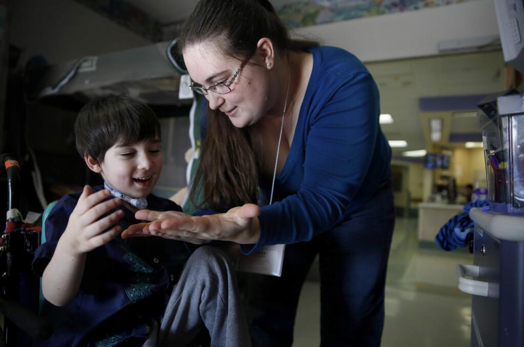 Sebastion Johnson, 4, reacts as his mother JamieLee Guglielmino does a magic trick with a coin in his room at UCSF Benioff Children's Hospital Oakland on Tuesday, January 20, 2015. (BETH SCHLANKER/ The Press Democrat)