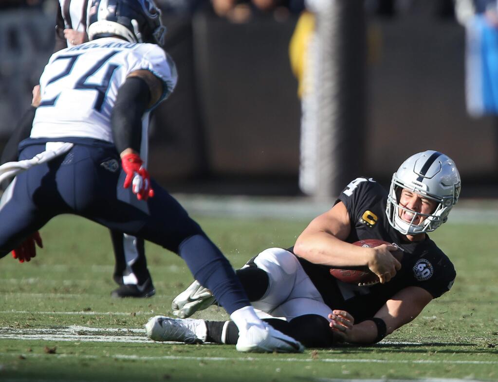 Oakland Raiders quarterback Derek Carr slides after scrambling with the ball against the Tennessee Titans during their game in Oakland on Sunday, December 8, 2019. (Christopher Chung/ The Press Democrat)