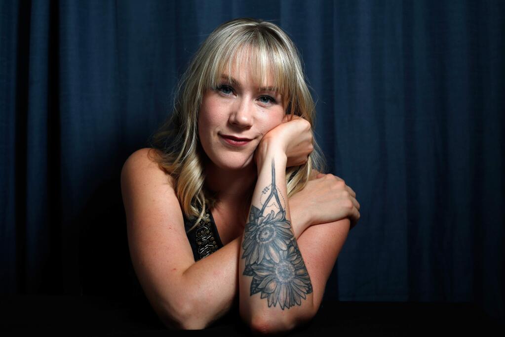 Artist Rachel Forbis poses for a portrait in Windsor, California, on Thursday, September 27, 2018. The tattoo of two sunflowers on Forbis's forearm represents the unborn twins she lost six months after the Tubbs Fire, as well as the number 222 for the address of her Larkfield neighborhood home which burned down in the Tubbs Fire. (Alvin Jornada / The Press Democrat)