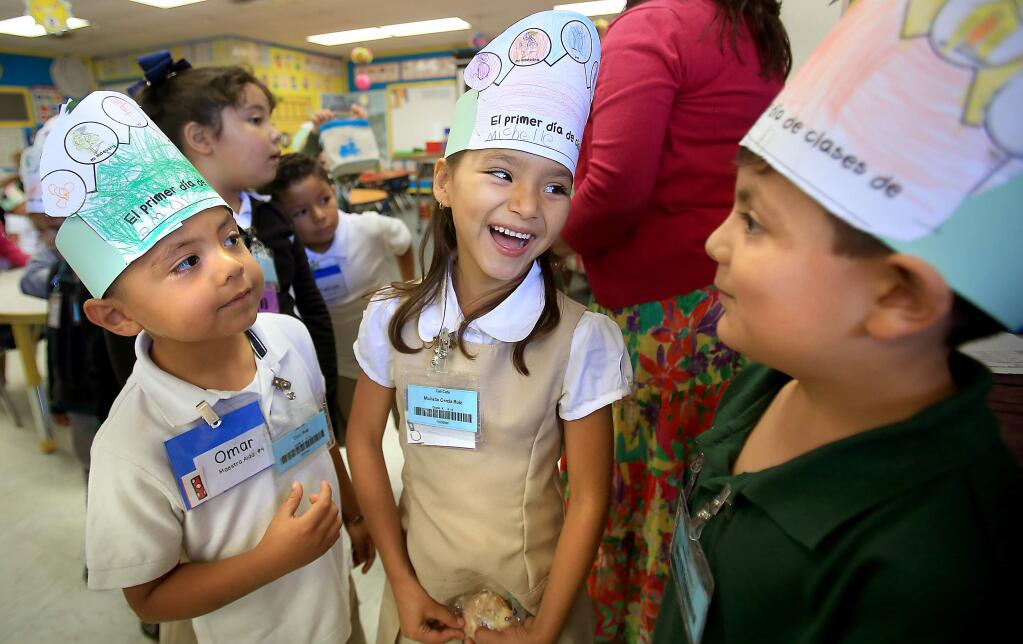 Cali Calmecac Language Academy kindergartners from left Omar Ruiz, Michelle Garcia Ruiz and Arath Magdaleno wrote and colored their names on hats during the first day of classes, Thursday Aug. 13, 2015 in Windsor (Kent Porter / Press Democrat) 2015