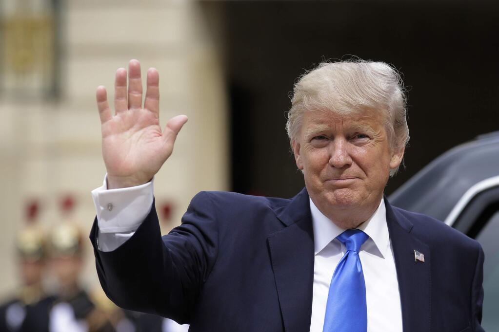 US President Donald Trump waves as he arrives for a meeting with French President Emmanuel Macron at the Elysee Palace in Paris, Thursday, July 13, 2017. Trump will be the parade's guest of honor to commemorate the 100th anniversary of the U.S. entry into World War I. U.S. troops will open the parade Friday as is traditional for the guest of honor. (AP Photo/Markus Schreiber)