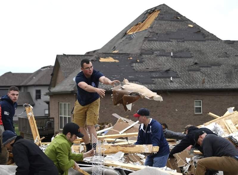 People work to clear debris Sunday, Feb. 25, 2018, after a fierce storm hit Saturday in the Farmington subdivision in Clarksville, Tennessee A strong storm system that included possible tornadoes roared eastward through the central United States, leaving demolished homes, damaged vehicles and uprooted trees in its wake. (Lacy Atkins/The Tennessean via AP)