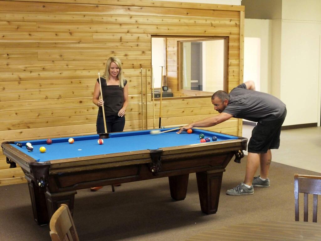 Mentor Me's Executive Director Deborah Dalton and Jason Rochlin of Rochlin Construction test out the pool table in the newly revamped game room at the Cavanagh Center. (Frank Simpson/For the Argus-Courier)