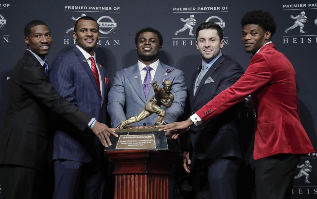 Heisman Trophy finalists, from left, Oklahoma's Dede Westbrook, Clemson's Deshaun Watson, Michigan's Jabrill Peppers, Oklahoma's Baker Mayfield and Louisville's Lamar Jackson stand for a photo with the Heisman Trophy before attending the Heisman Trophy award ceremony, Saturday, Dec. 10, 2016, in New York. (AP Photo/Julie Jacobson)